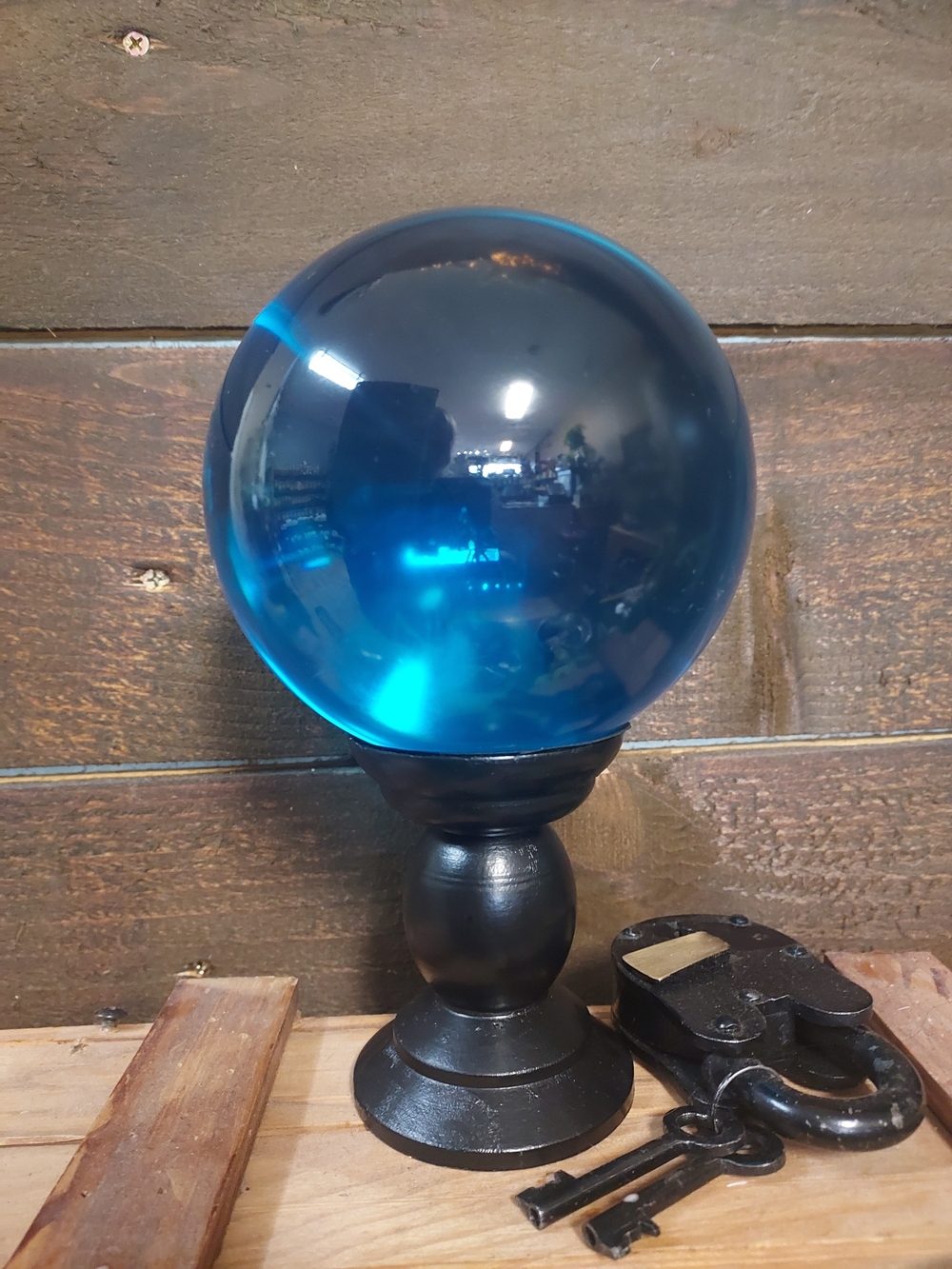 Blue Glass Gazing Ball on Black Pedestal